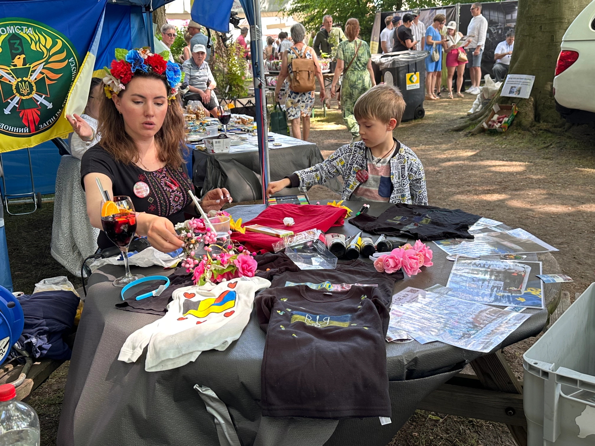 Stand van BE-84Ukraine met Oekraïense merchandise en patches